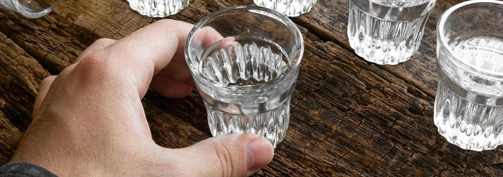 Man holding shot glass with alcohol
