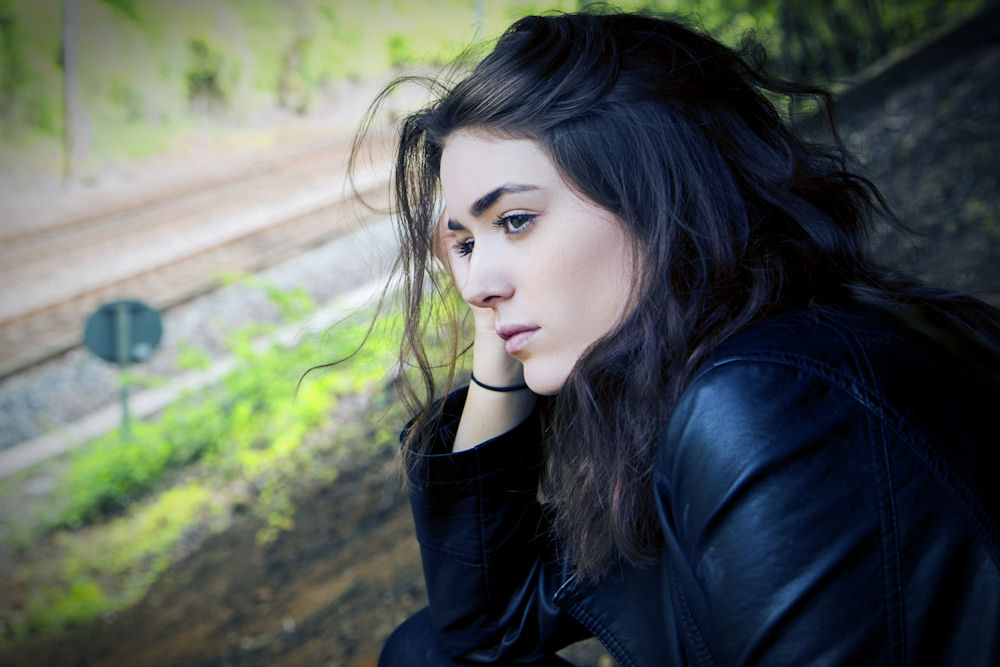 Woman looking out window, facing co-occurring disorders